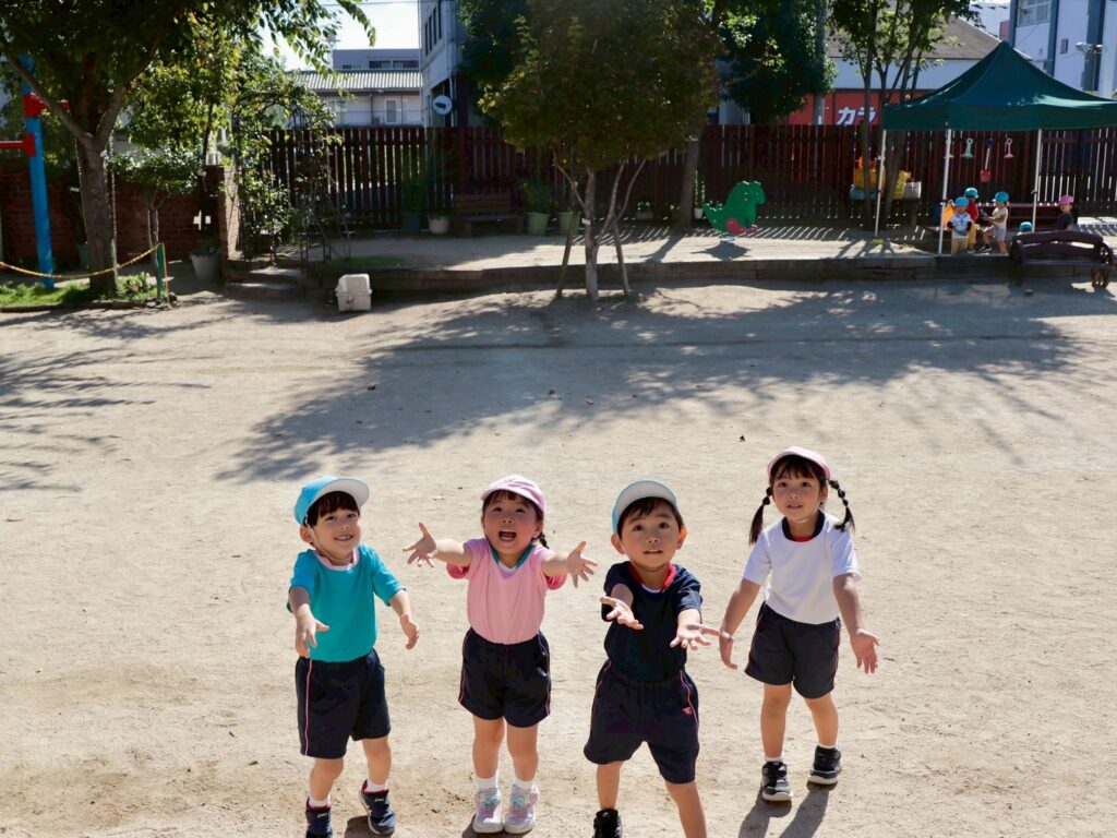 呉中央幼稚園の体操服と園庭で遊ぶ園児達